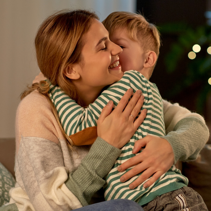 Mother cuddling with son A mother is cuddling her son in a cozy environment in sofa