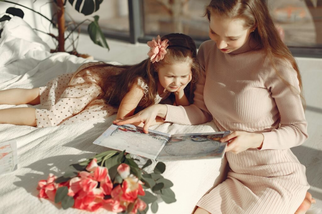 A mother and her daughter is reading a book in bed