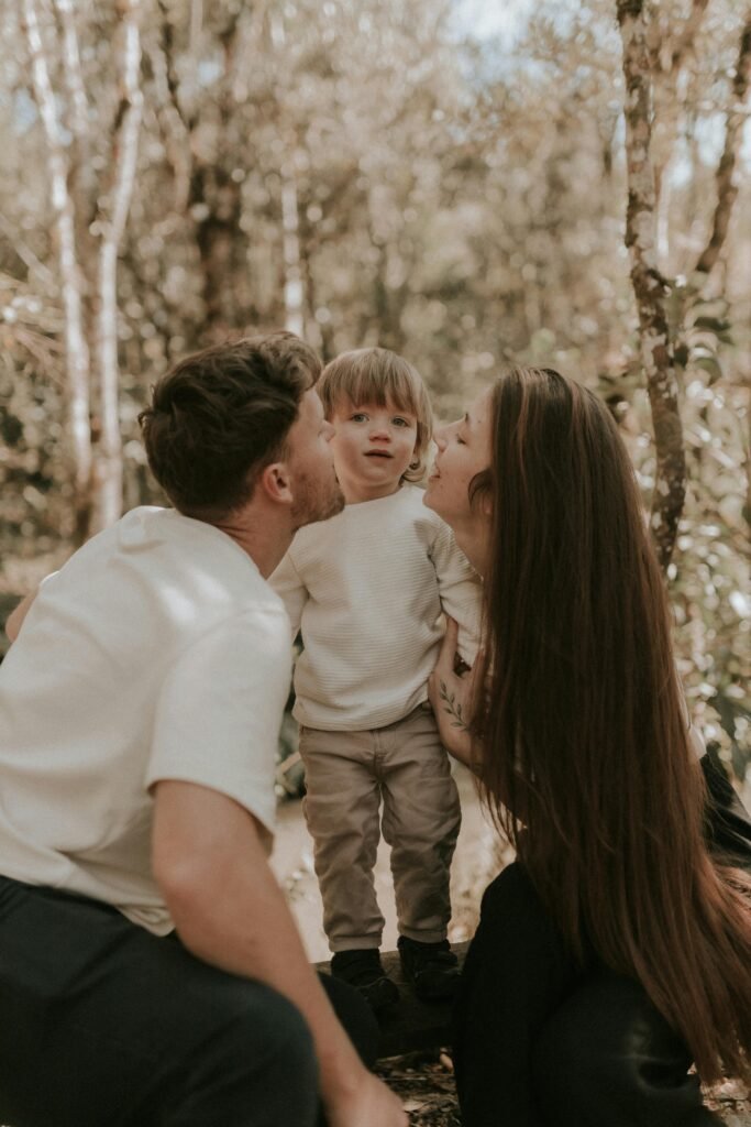 Gentle parenting parents kissing son Gentle parenting a mother and father kissing their son