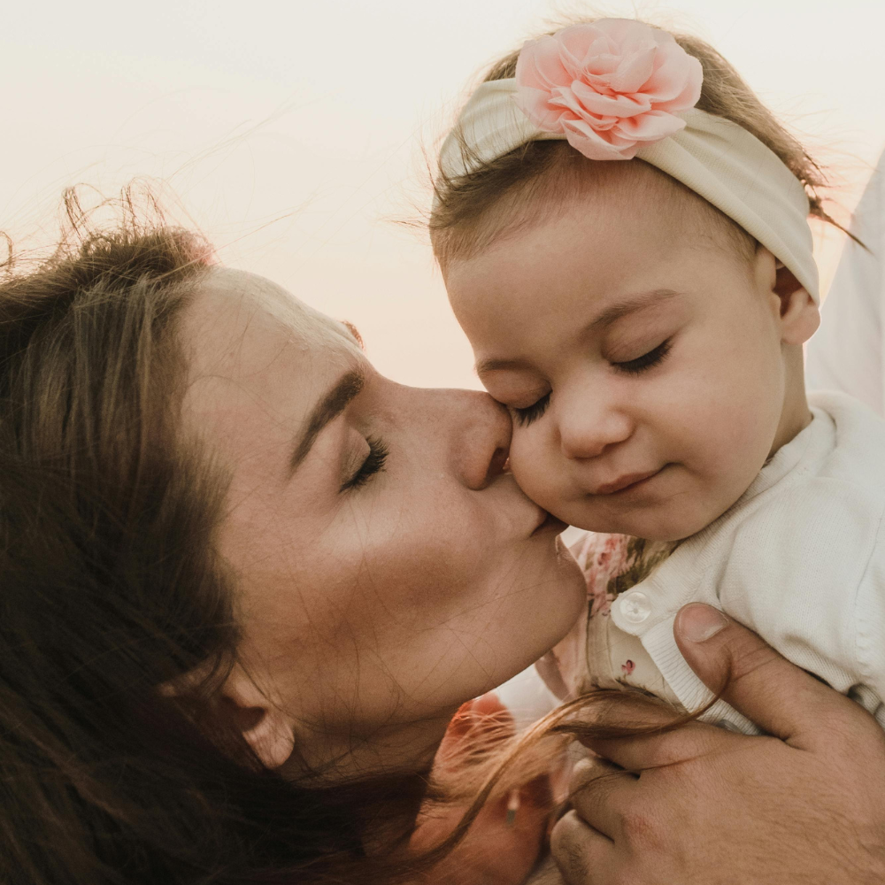 Gentle vs. Uninvolved a loving mother gently kissing her daughters cheeks