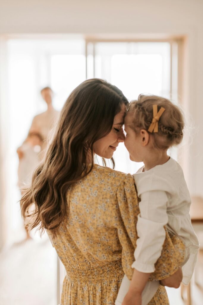 Gentle parenting mother is carrying her daughter in her loving arms