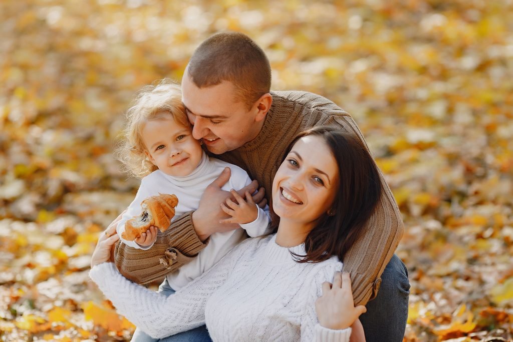 Family playing together in autumn leaves