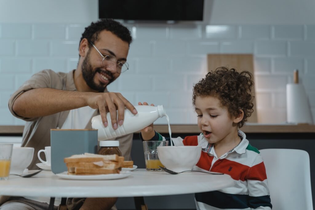 Parent supporting a toddler with an everyday task while leaving room for independence
